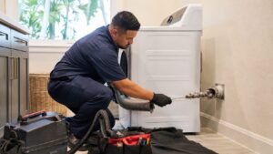 Technician Cleaning a Clogged Dryer Vent